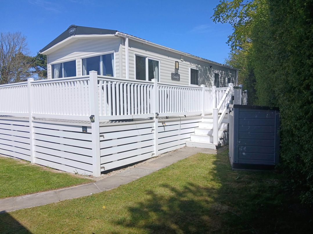 A mobile home with a deck and garden at Porthcurno 5, Perranwell near Goonhavern