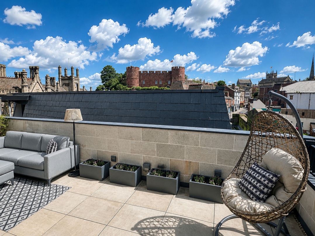 A roof terrace with a sofa and hanging chair at Luxury two story Penthouse with roof top terrace in Shrewsbury