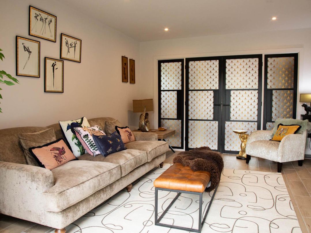 A living room with a sofa and artworks at House Sleeps 10 with Enclosed Garden