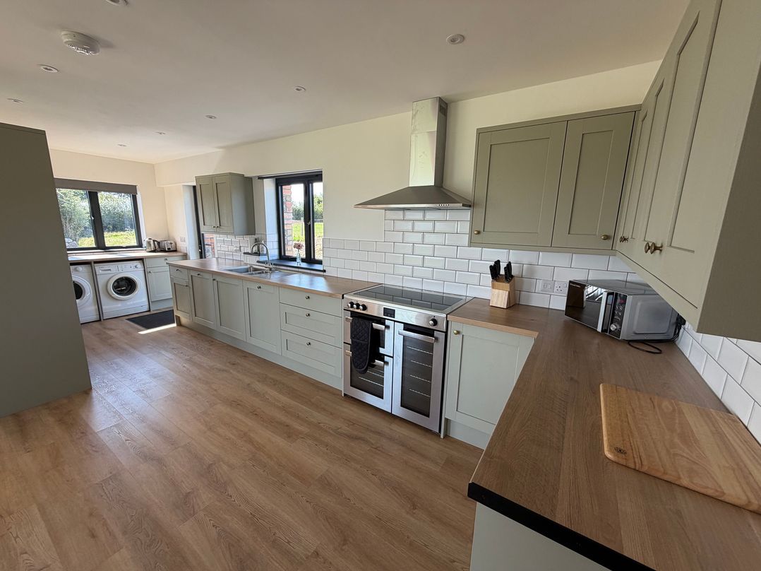 A kitchen with a washing machine and oven at High View Barn in Launceston
