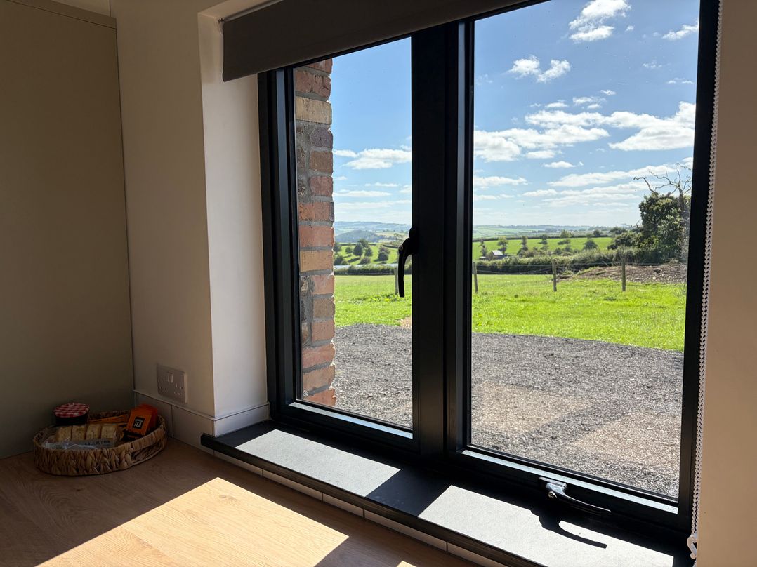 A window with a view and a basket of snacks at High View Barn Launceston