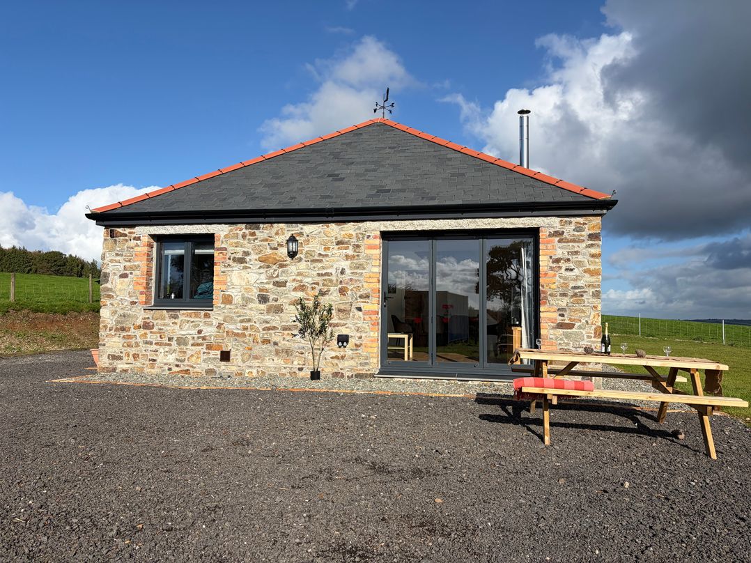 A stone building with a table and benches at High View Barn Launceston