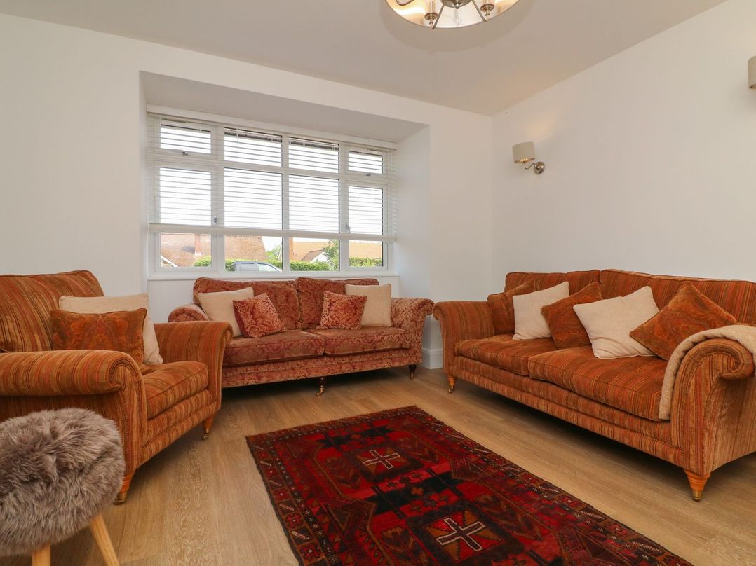 A living room with two sofas and a rug at Wendy's Cottage in Minehead
