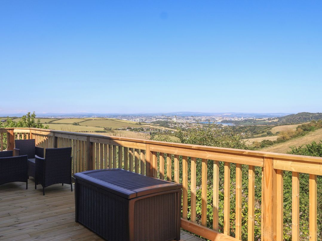 An outdoor deck with chairs and a table overlooking a landscape at Lodge 19 Millbrook