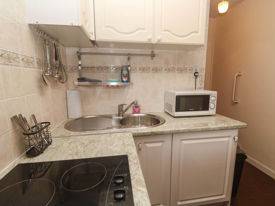 A kitchen with a sink, microwave, and stove at Chyancrowse in Gulval