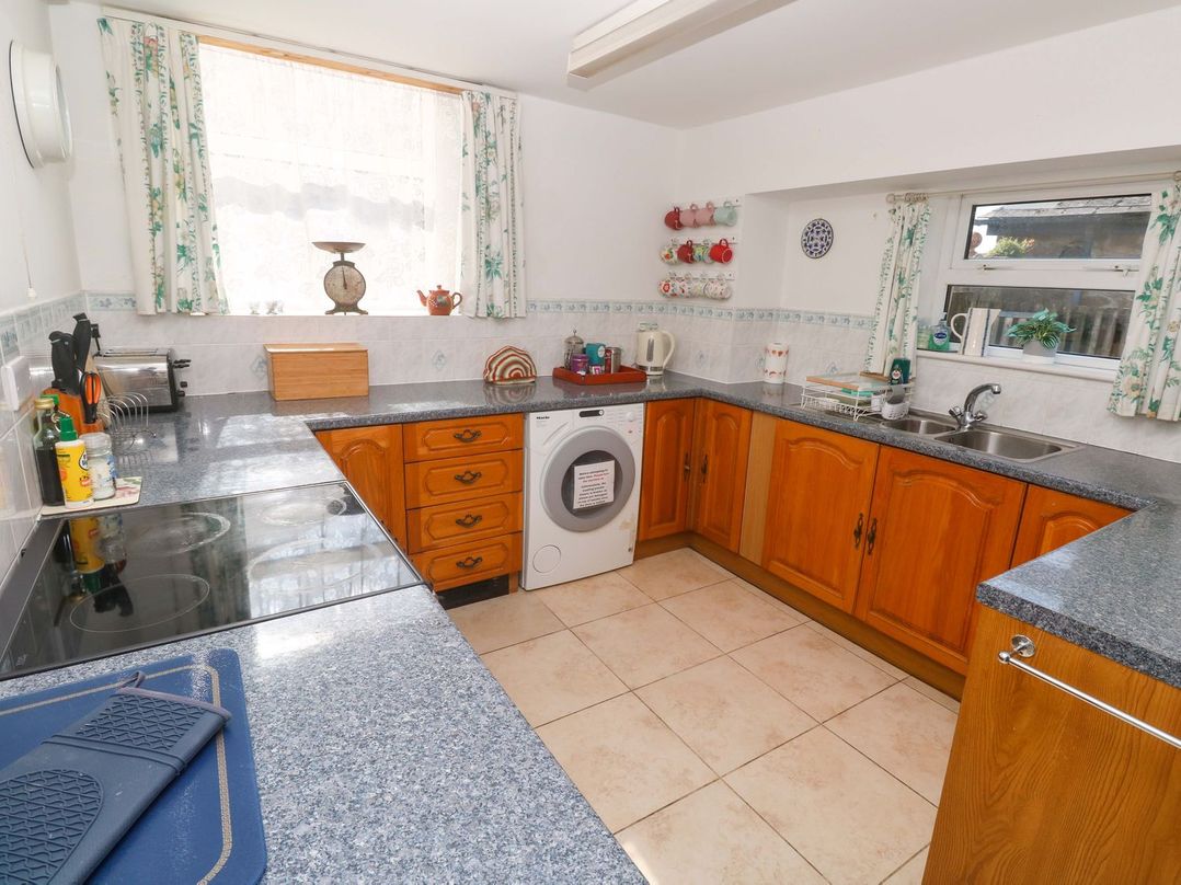 A kitchen with wooden cabinets and appliances at Chyandaunce in Penzance