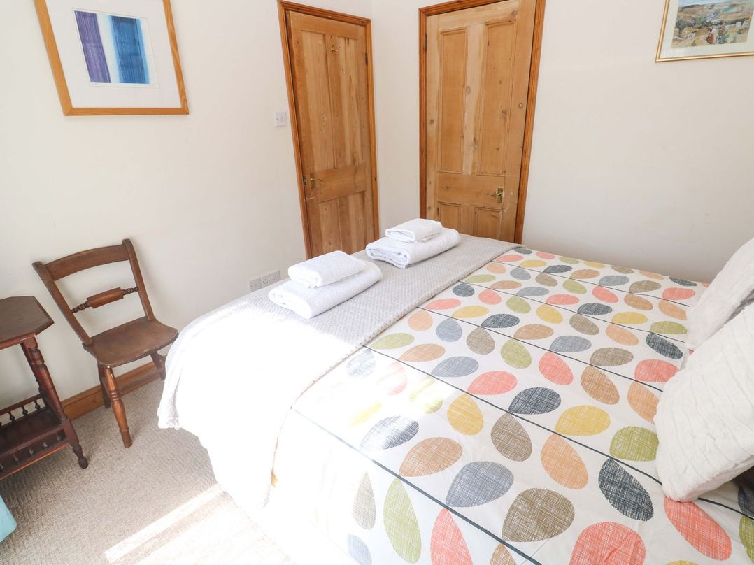 A bedroom with a bed and chairs at Chyandaunce in Penzance