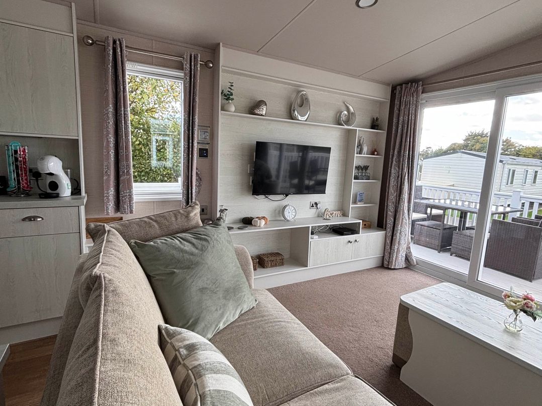 A living room with a sofa and television at Primrose Valley Park - Pebbles Retreat in Primrose Valley