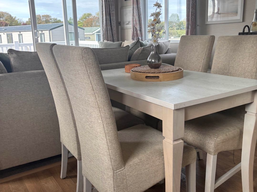 A dining table with chairs and decor at Primrose Valley Park - Pebbles Retreat Primrose Valley