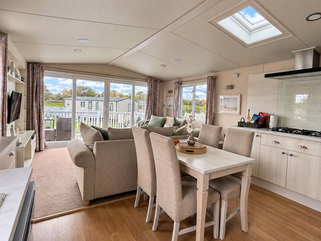 A living room with a sofa and dining area at Primrose Valley Park - Pebbles Retreat in Primrose Valley