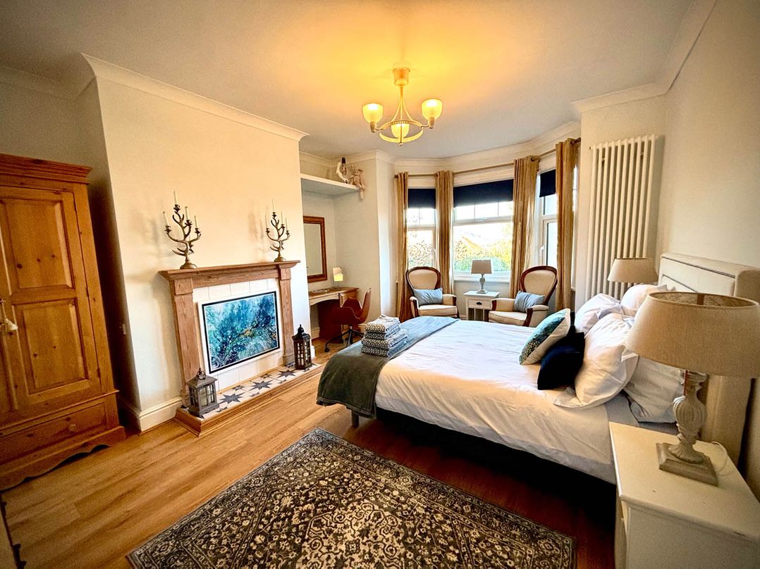 A bedroom with a bed and armchairs at 5 Guests  2 Bedrooms  Free Parking 1min Beach Llandudno