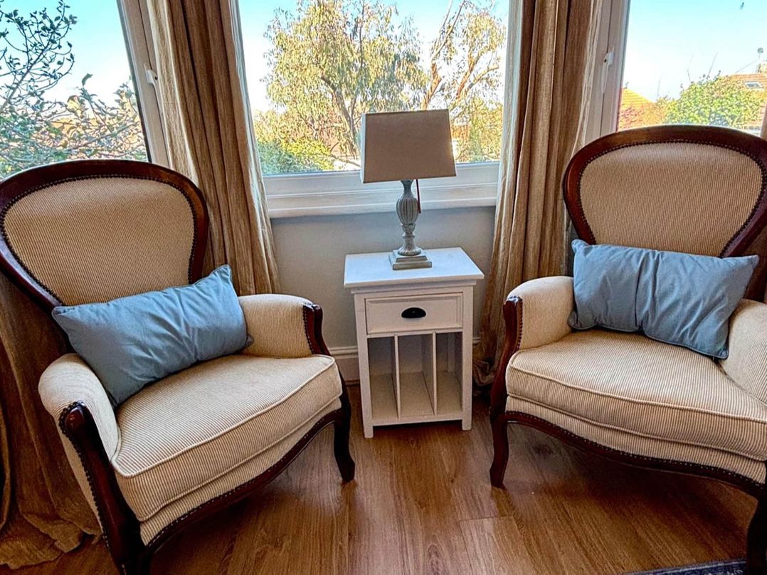 Two armchairs and a lamp next to a window at 5 Guests  2 Bedrooms  Free Parking 1min Beach Llandudno