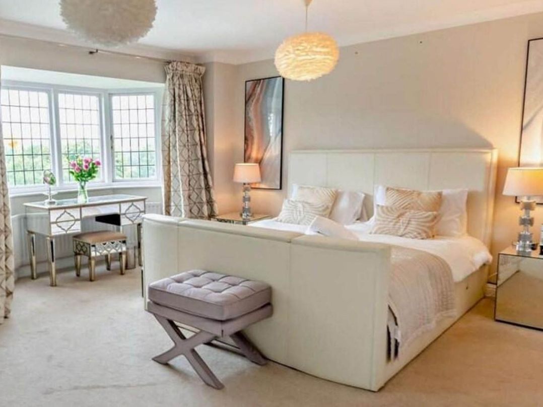 A bedroom with a bed, desk, chair, and flowers at Luxurious 5 Bedroom House in Cookham near Marlow
