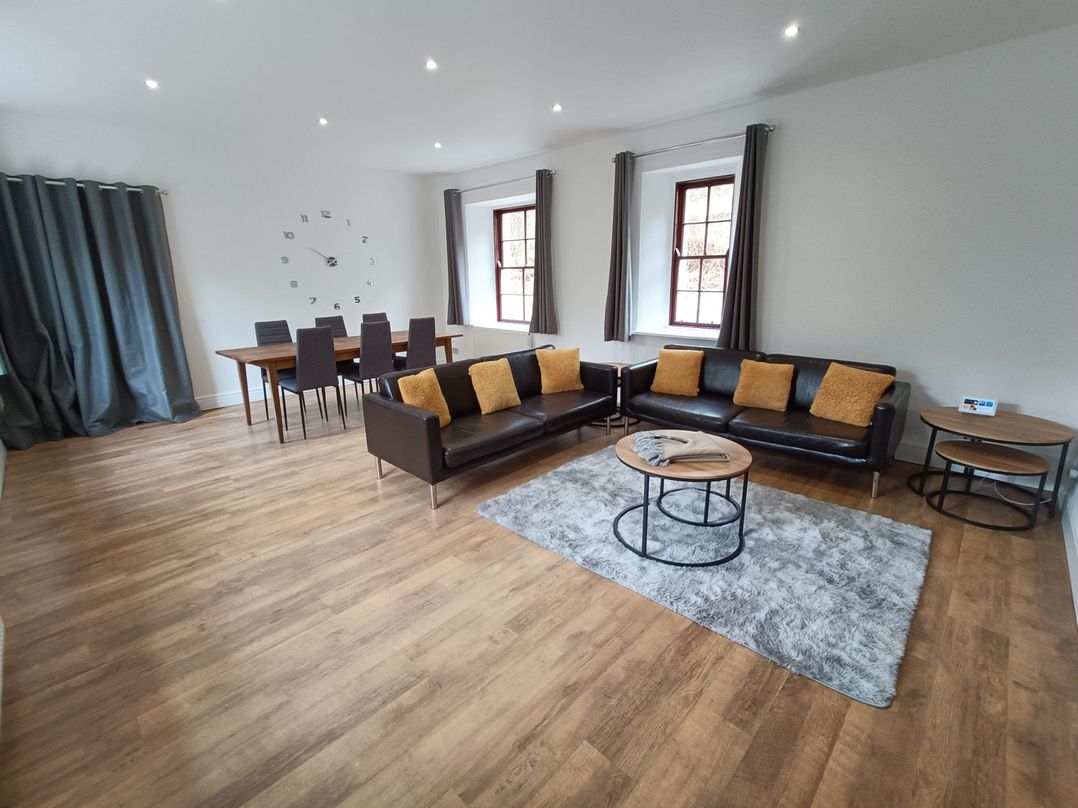 A living room with a sofa and dining table at RnB Rural n Beautiful Near Barrhill