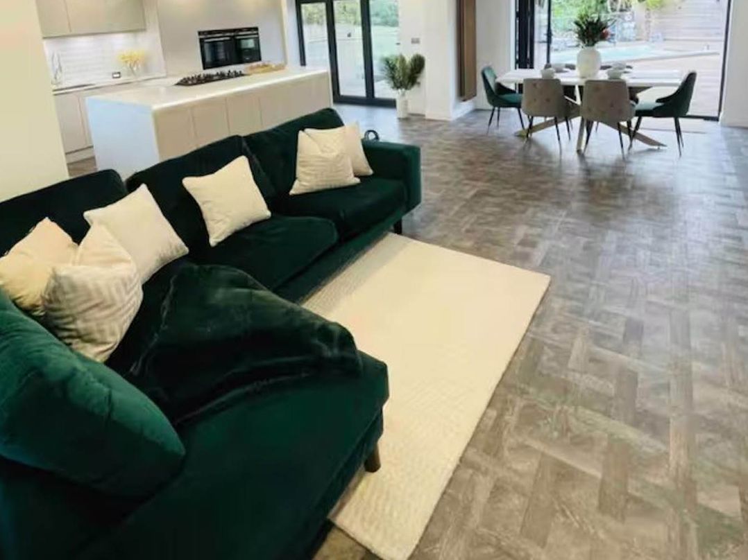 A living room with a sofa and dining area at Hot tub  BBQ  Garden Parking  Sleeps 8 Worcester