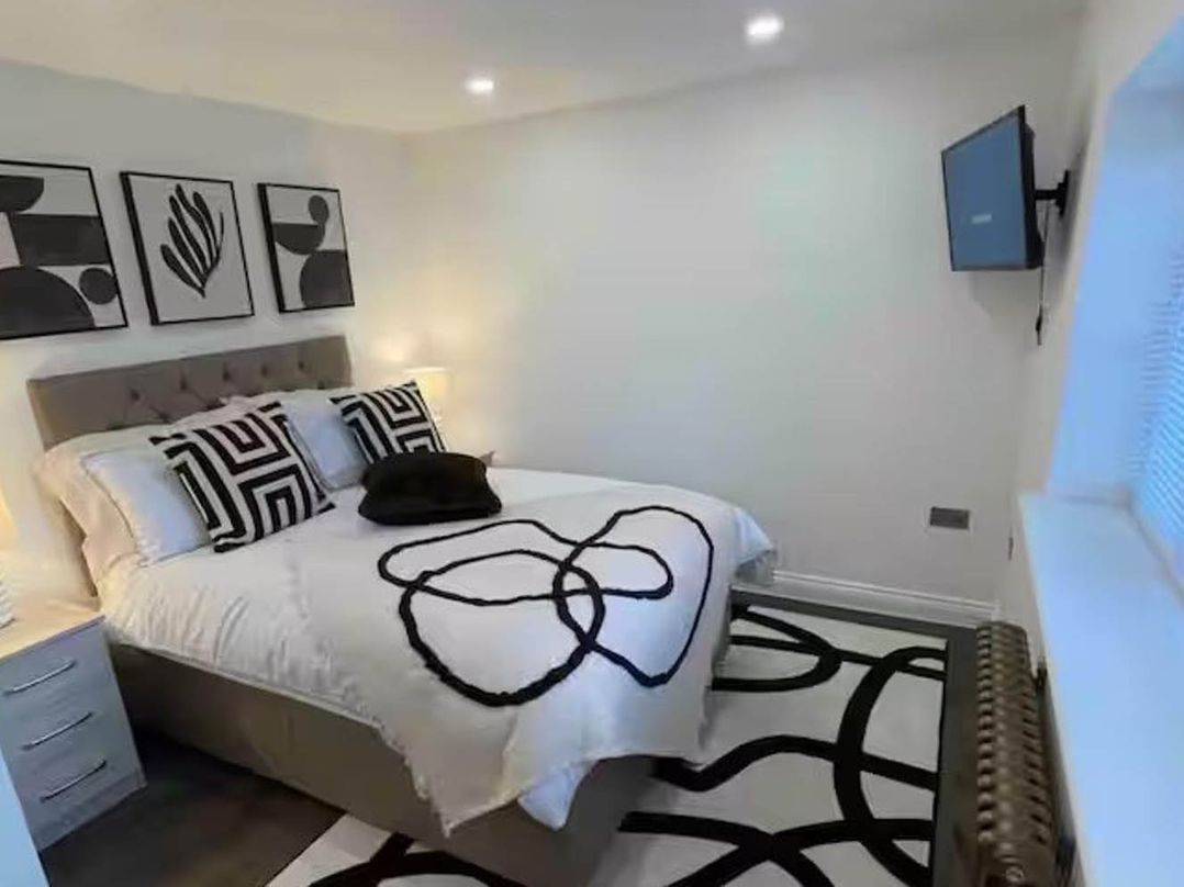 A bedroom with a bed and artwork on the wall at Hot tub  BBQ  Garden Parking  Sleeps 8 in Worcester
