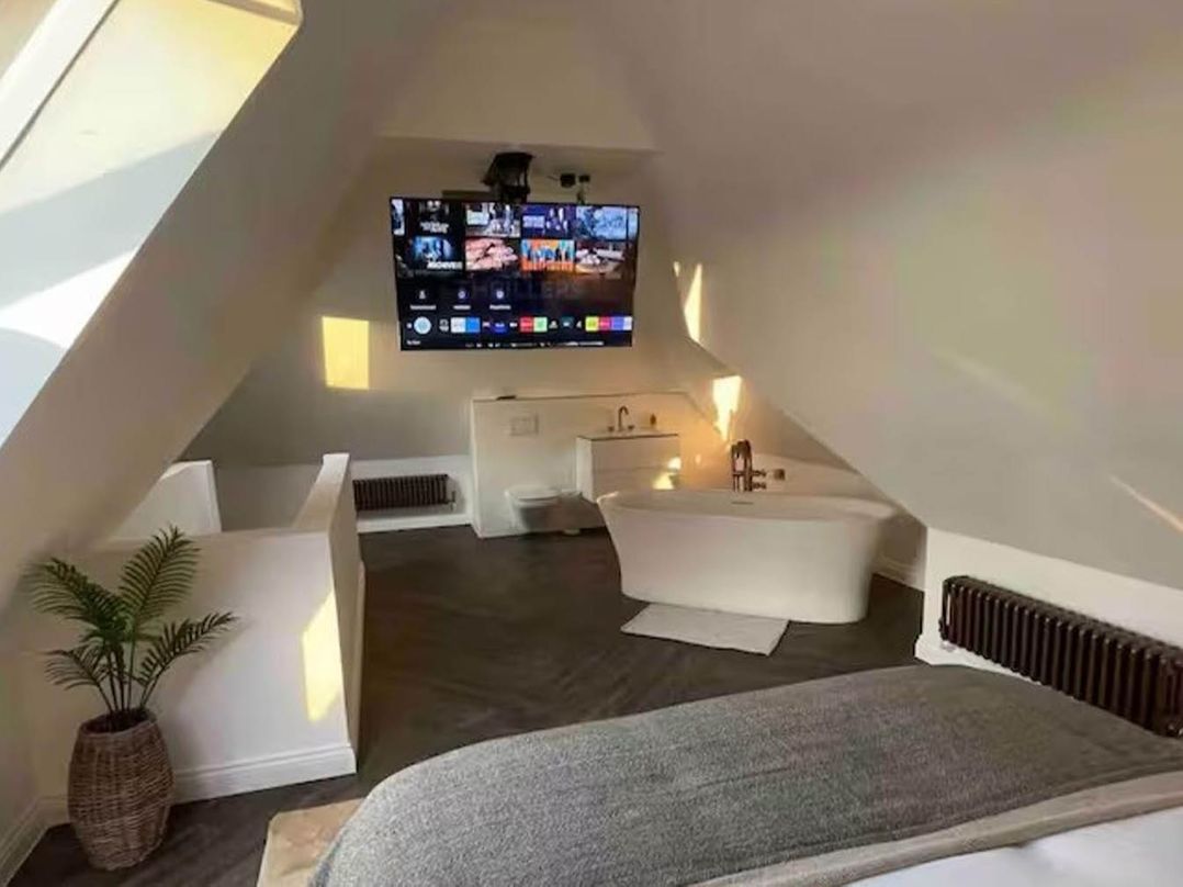 A bathroom with a bathtub and television at Hot tub BBQ Garden Parking Sleeps 8 Worcester