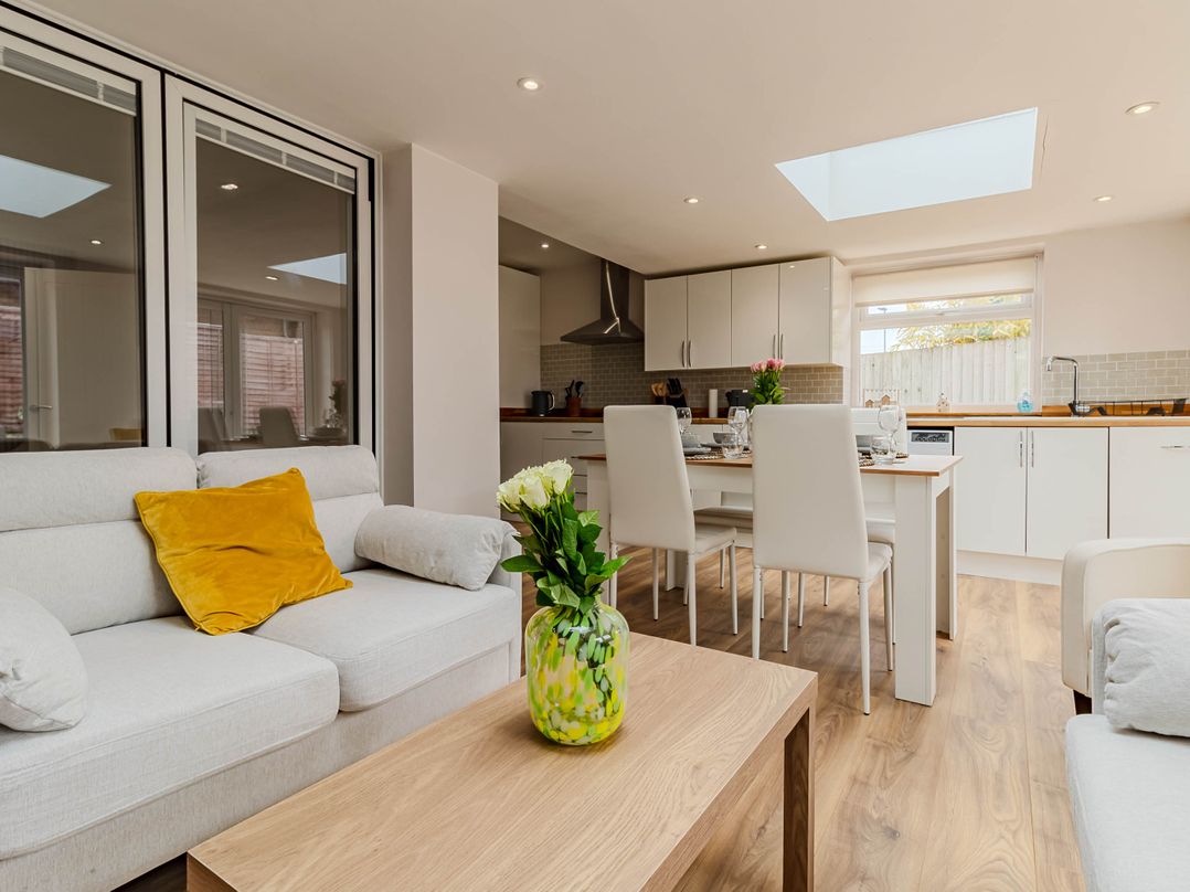 A living room with a sofa and dining area at Loughborough Luxe Bungalow Retreat Sleeps 6 in Shepshed