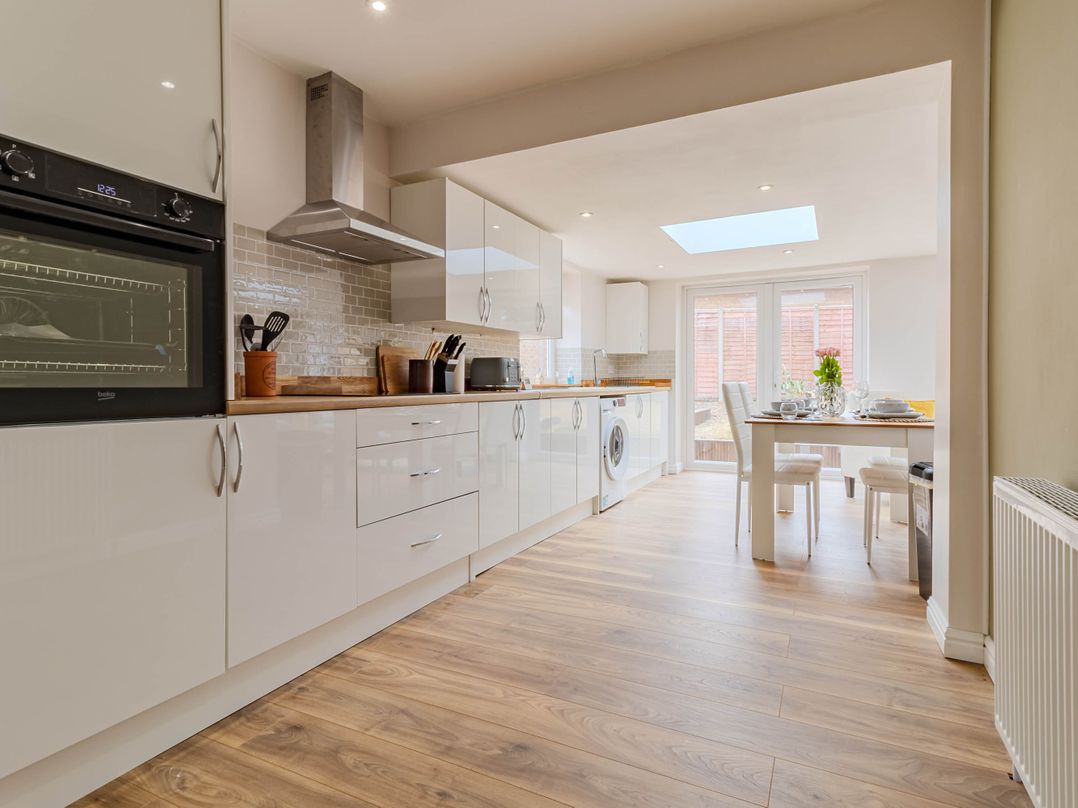 A kitchen with modern appliances and a dining table at Loughborough Luxe Bungalow Retreat Sleeps 6 in Shepshed