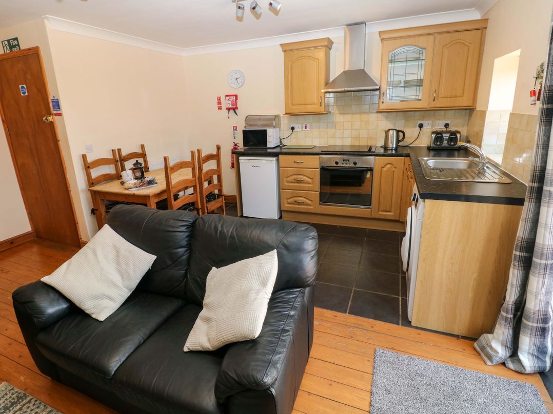 A kitchen with seating area and appliances at The Dairy in Penuel near Llanmorlais