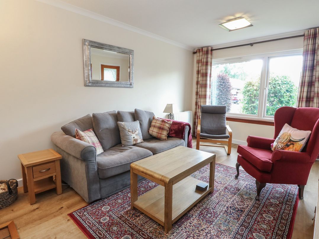 A living room with a sofa and coffee table at Steam Cottage in Aviemore