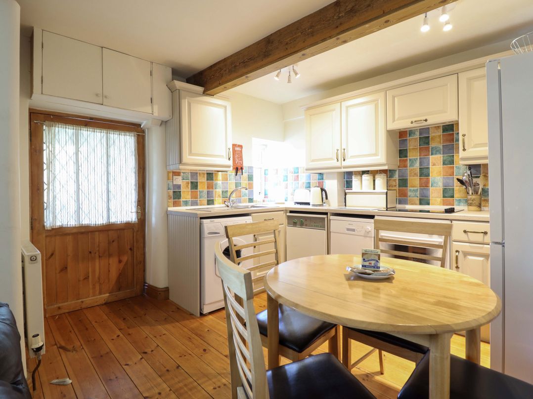 A kitchen with a table and chairs at Stabal Cottage in Dolgellau