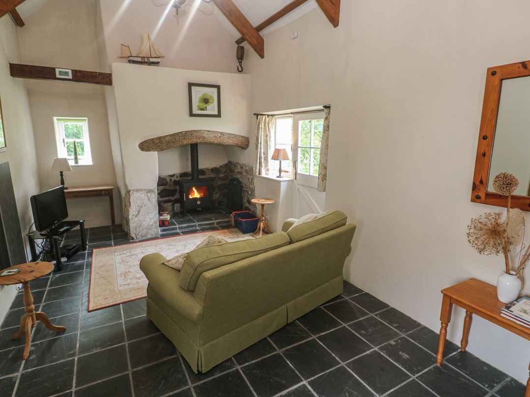 A living room with a sofa and television at Swallows, St Keverne, Lizard Peninsula