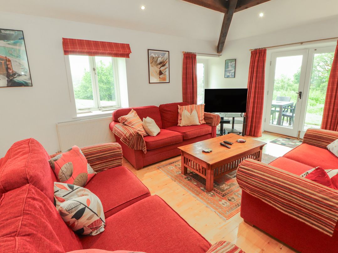 A living room with a sofa and television at Winster Fields in Cartmel Fell near Windermere