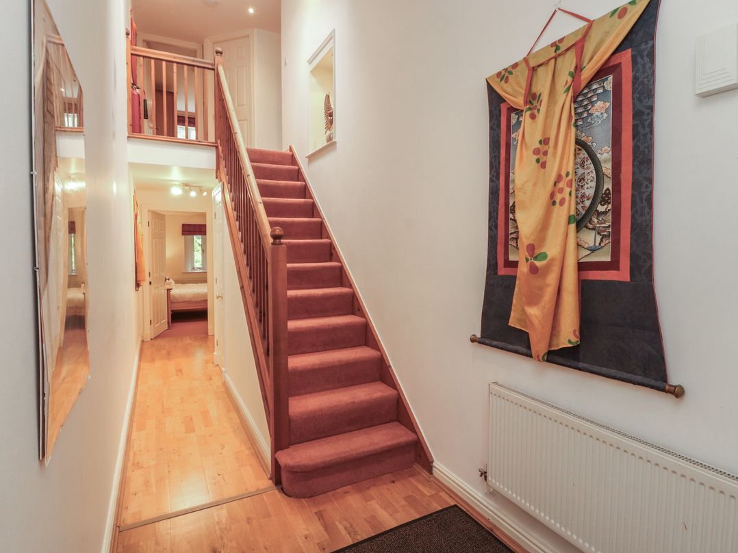 A hallway with stairs and a mirror at Winster Fields Cartmel Fell near Windermere
