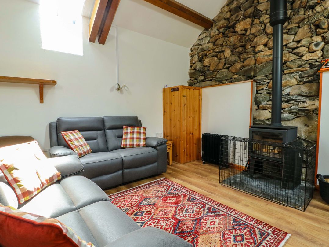 A living room with a sofa and a fireplace at Bythyn Ddol Hafod in Capel Curig