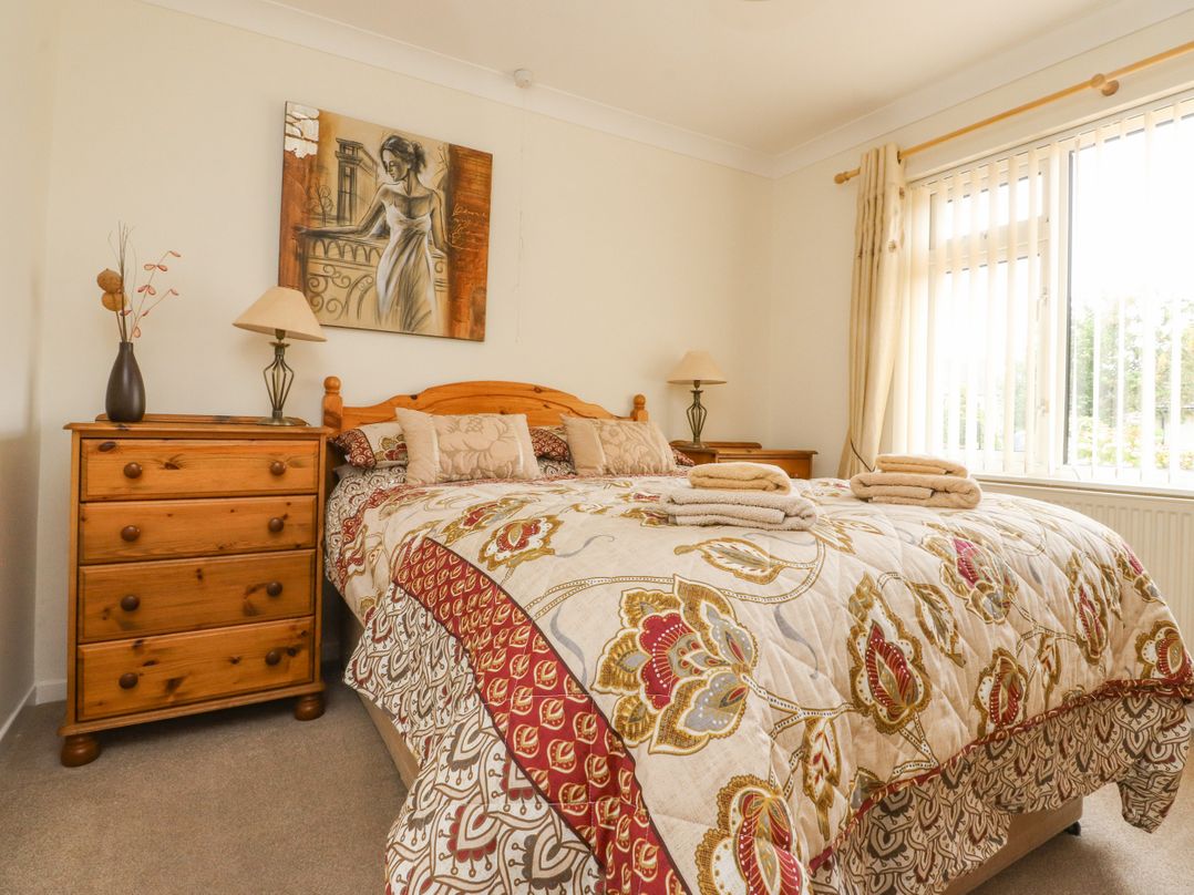 A bedroom with a bed and dresser at Wynnville in Embsay near Skipton