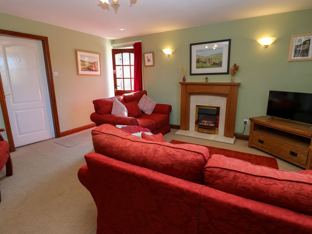 A living room with a sofa and television at Barnbrook Carperby near Leyburn