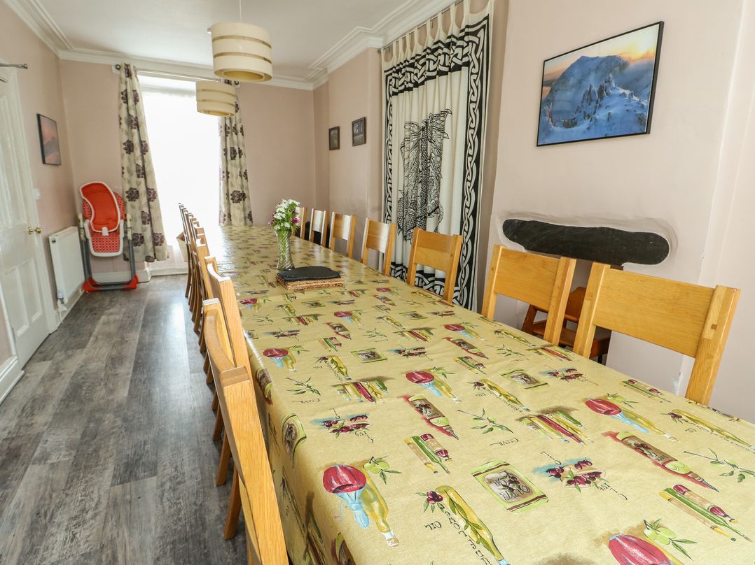 A dining room with a long table and chairs at Halford Hill in Llanberis