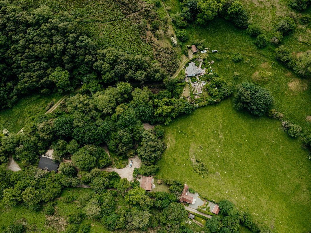 An aerial view of a house surrounded by trees and fields at The Wilderness in Stiperstones