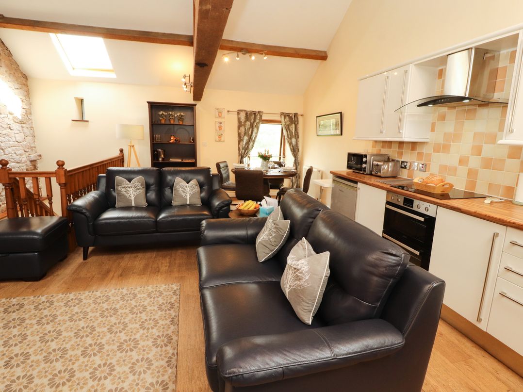 A living room with sofas and a dining area at Stable Cottage, Bolton Low Houses