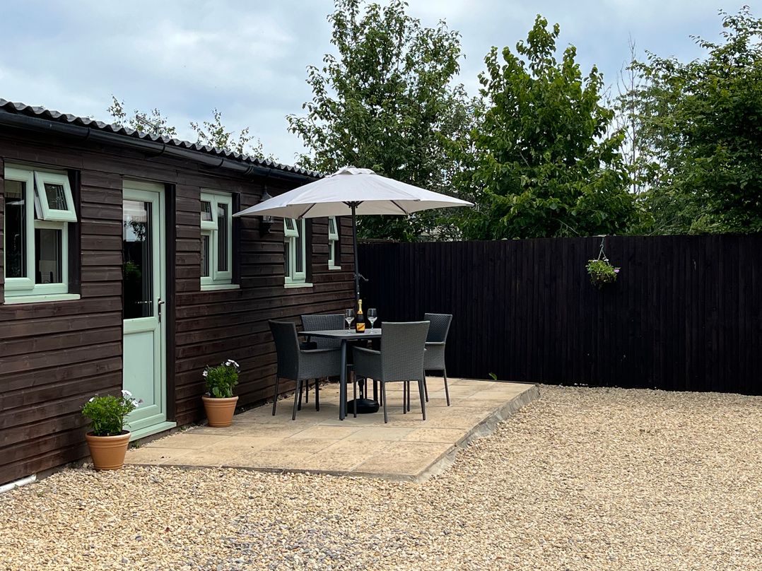 An outdoor seating area with a table and chairs at Garden Cottage, Rode Farm Rode