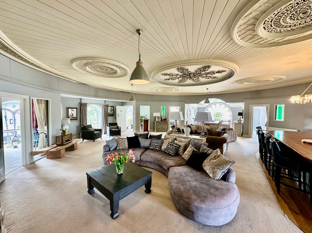 A living room with multiple seating areas and large windows at Capel Mawr Llanrug near Llanberis