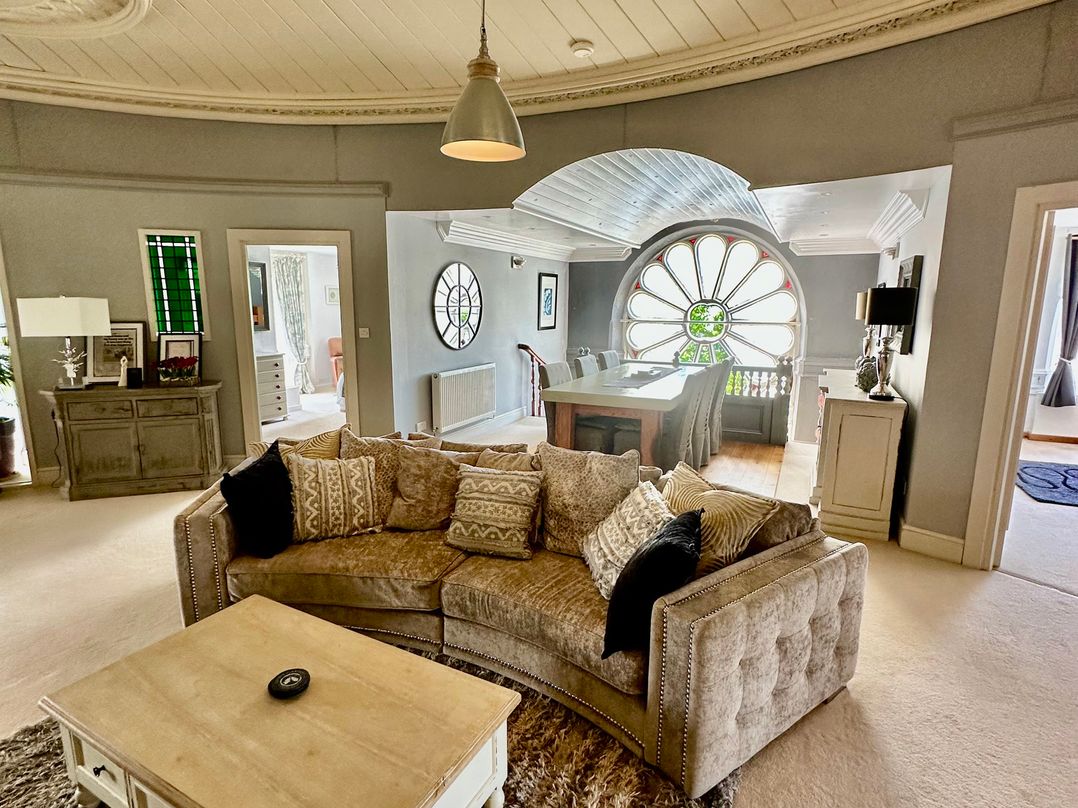 A living room with a sofa and dining area at Capel Mawr in Llanrug near Llanberis