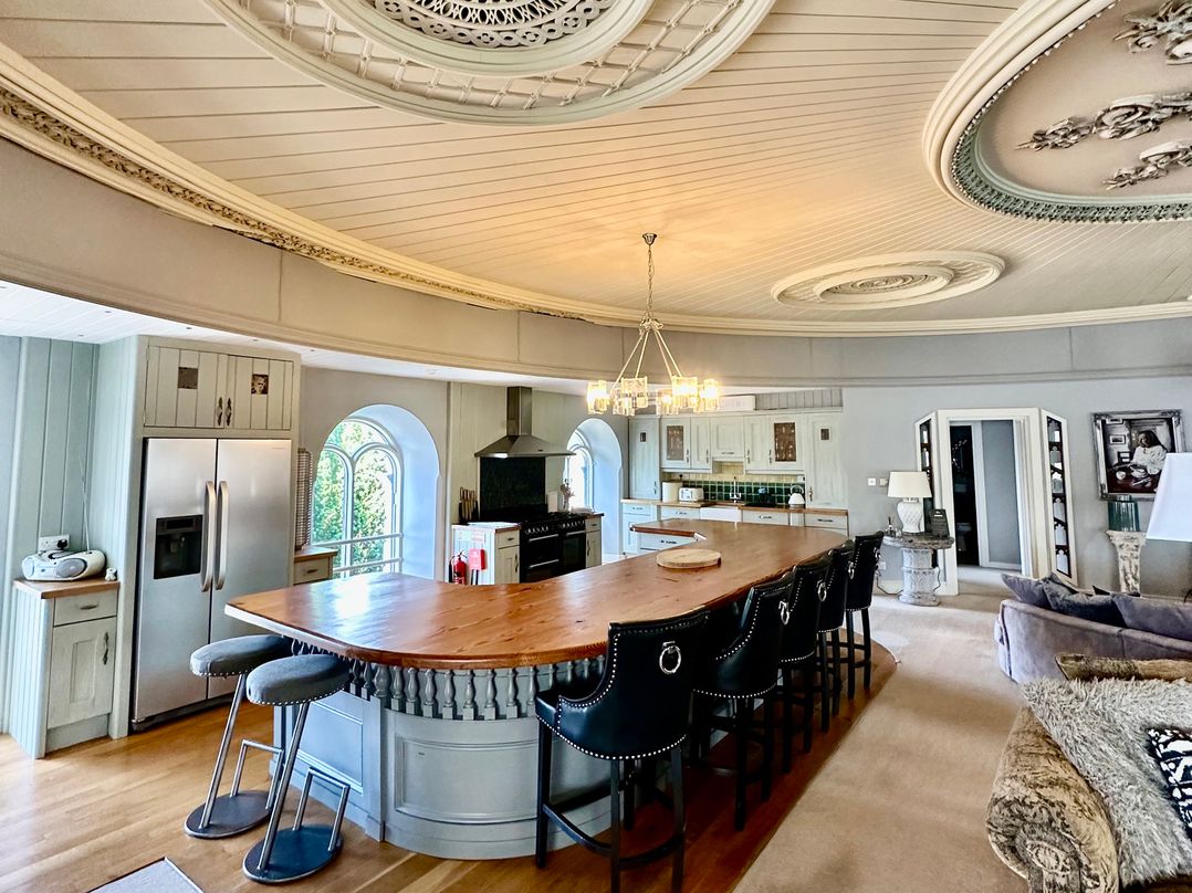 A kitchen with an island and bar stools at Capel Mawr in Llanrug near Llanberis