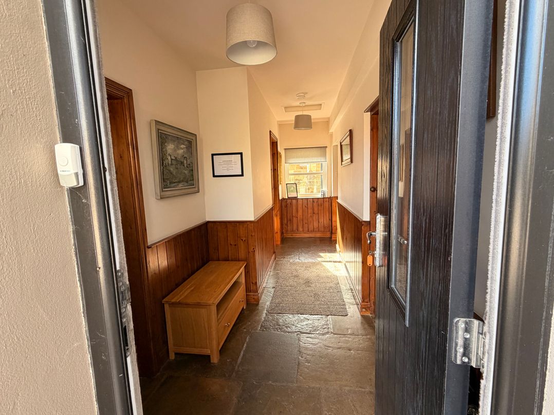 A hallway with a bench and picture frame at The Farmhouse in Boggle Hole near Robin Hood's Bay