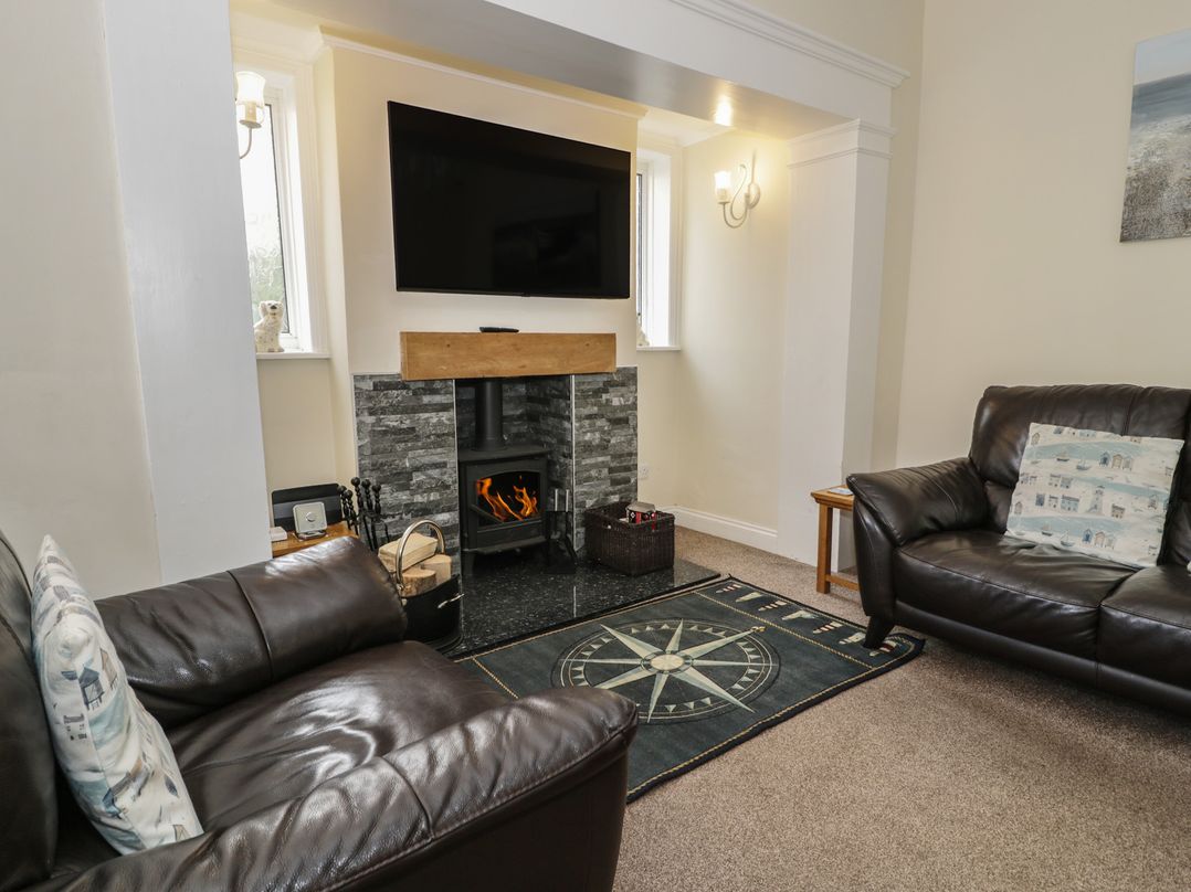 A living room with a fireplace and television at Roma in Rhos-on-Sea