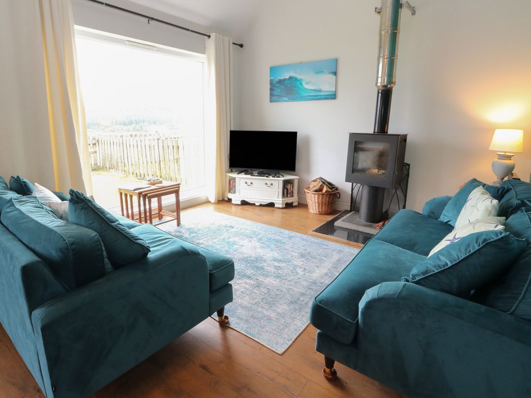 A living room with sofas and a television at Starfish Cottage, Craignure, Isle Of Mull