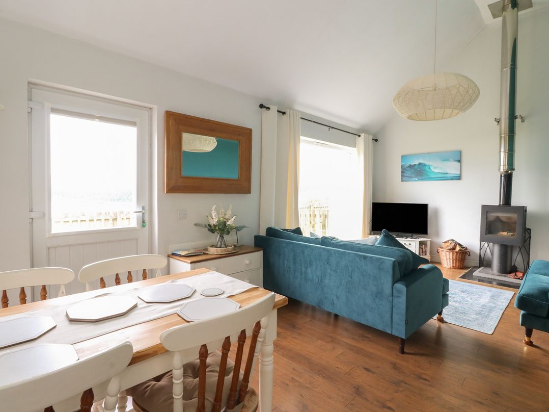 A dining table and sofa in a living room at Starfish Cottage, Craignure, Isle Of Mull