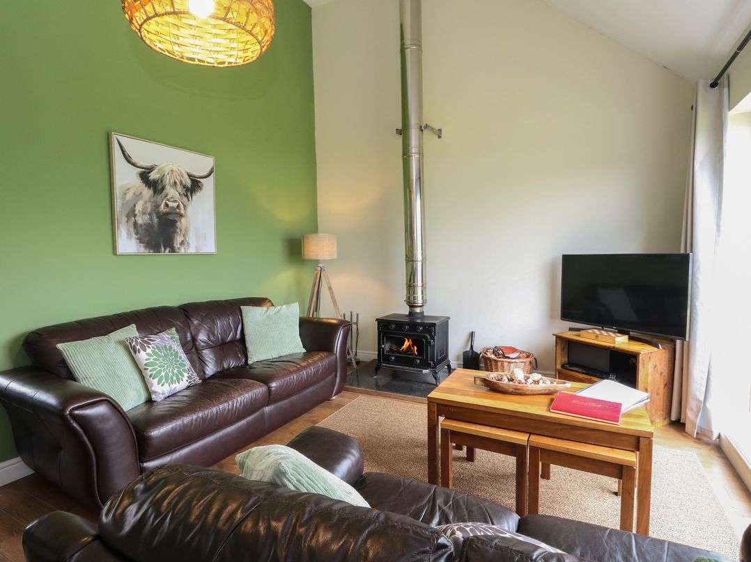 A living room with a sofa and coffee table at Driftwood Cottage, Craignure, Isle Of Mull