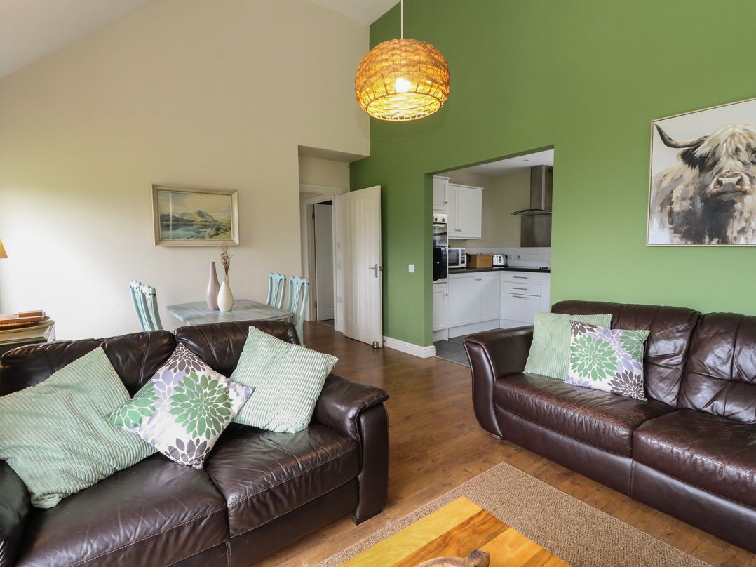 A living room with sofas and a dining table at Driftwood Cottage in Craignure Isle Of Mull