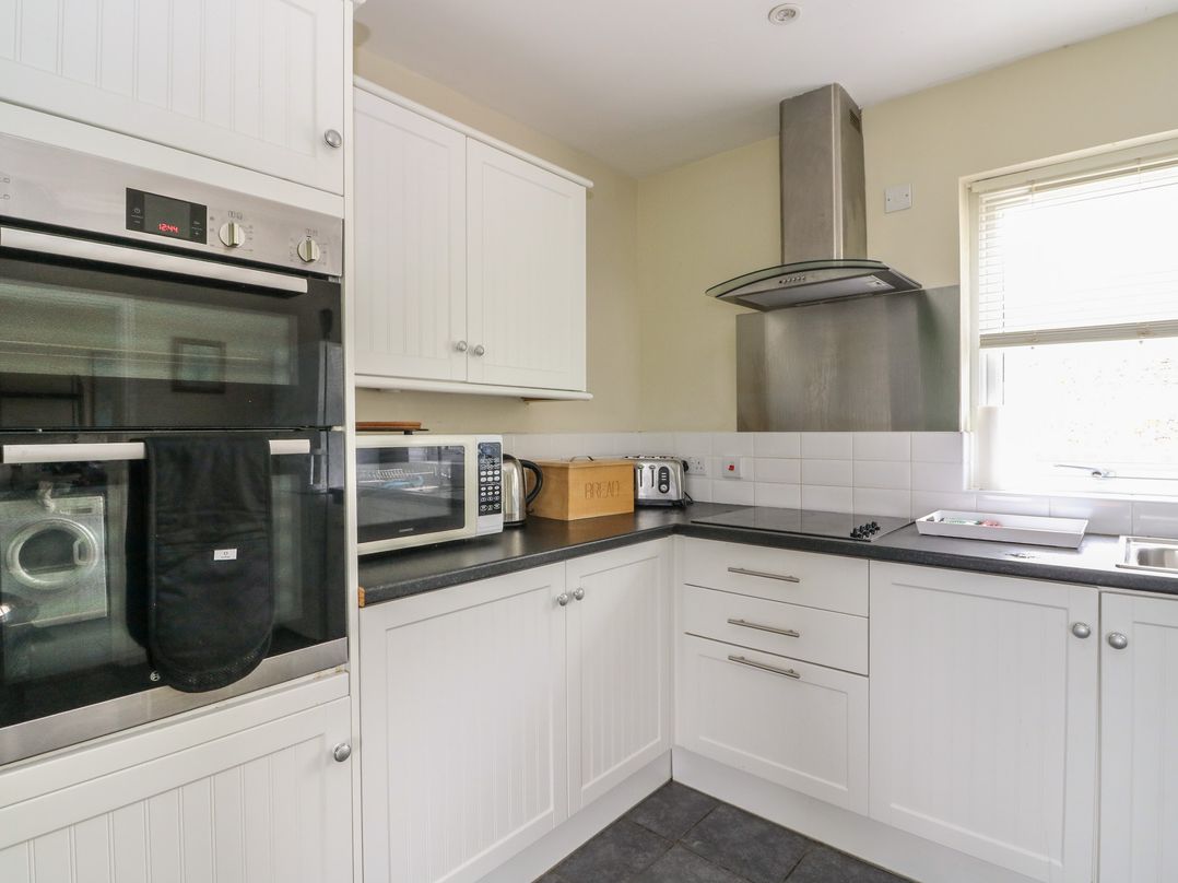 A kitchen with an oven, microwave, and kettle at Driftwood Cottage, Craignure, Isle Of Mull