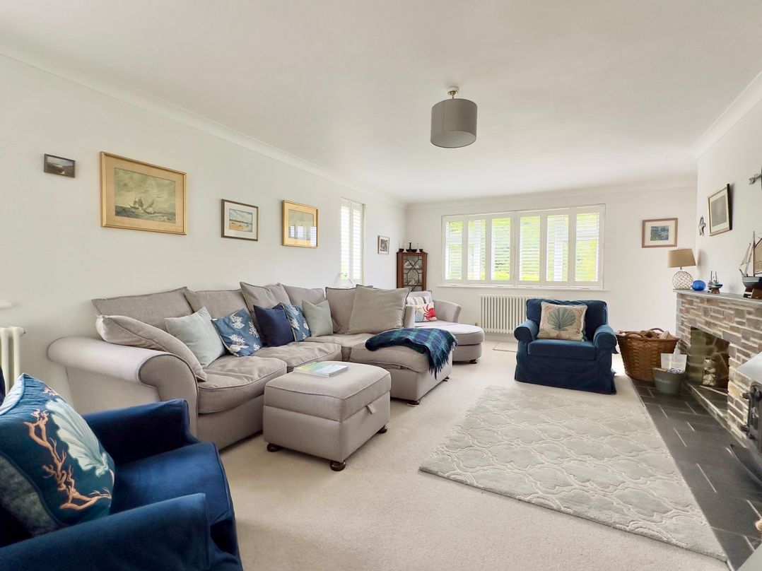 A living room with a sofa and armchair at Kilcarreg in Rock near Wadebridge