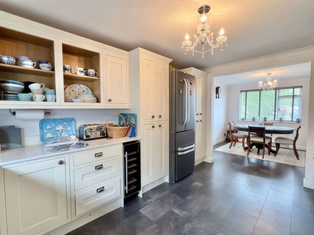 A kitchen with cabinets and a dining area at Kilcarreg in Rock near Wadebridge