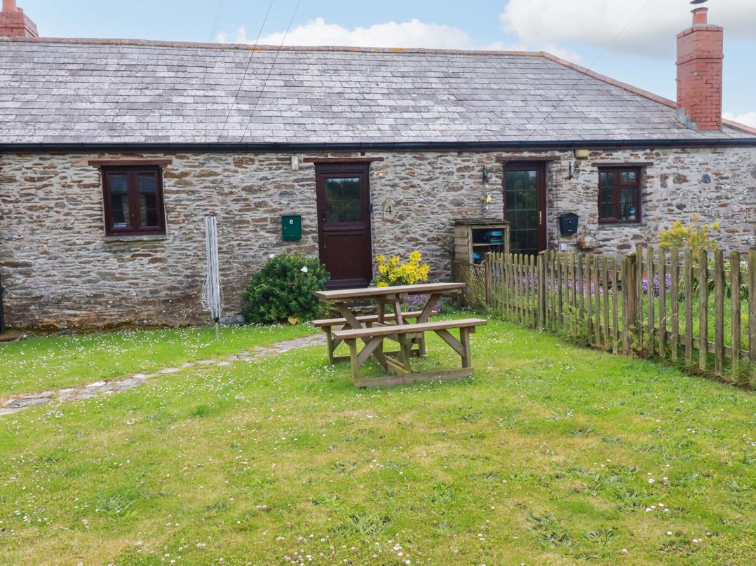 A cottage with a picnic table and garden at 4 Mowhay Cottages in Gorran Haven