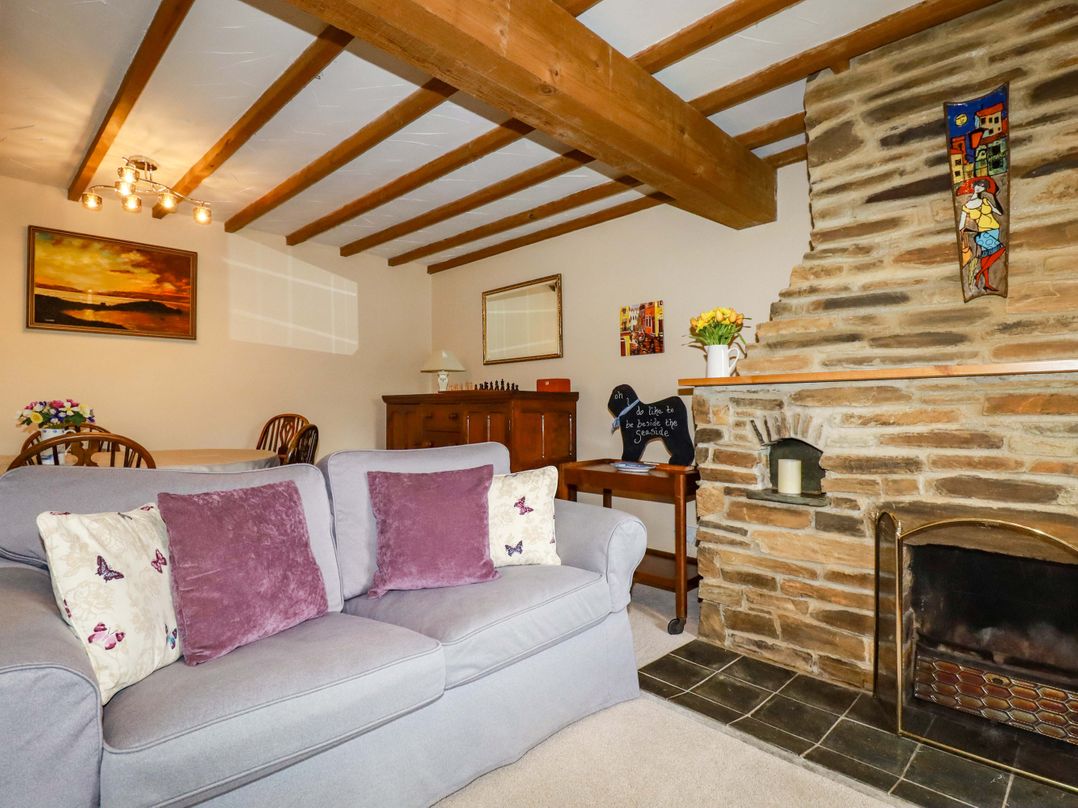 A living room with a sofa and a fireplace at 4 Mowhay Cottages Gorran Haven